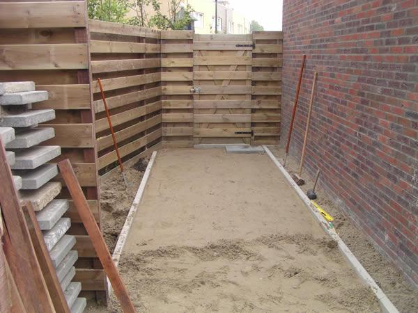 Het zandbed van de bestrating van de "achterom".